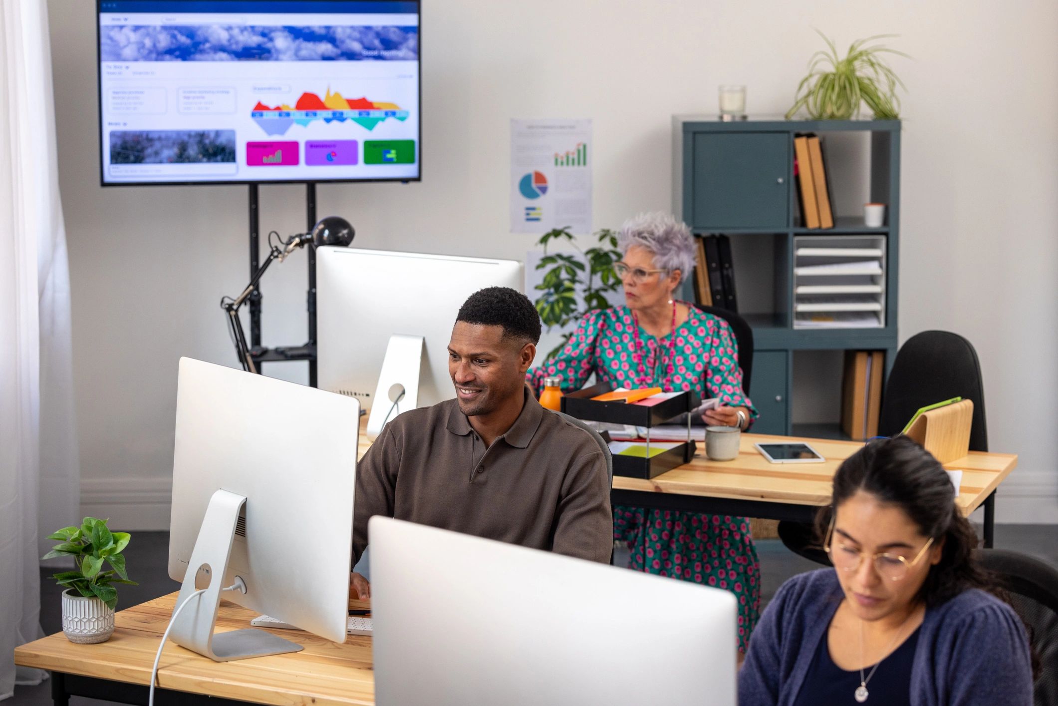 Technology professionals reviewing analytics dashboards in a modern office