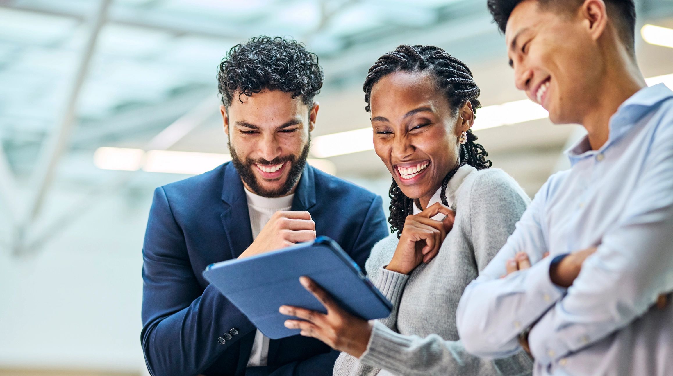 African technology professionals celebrating success around a tablet in a modern office